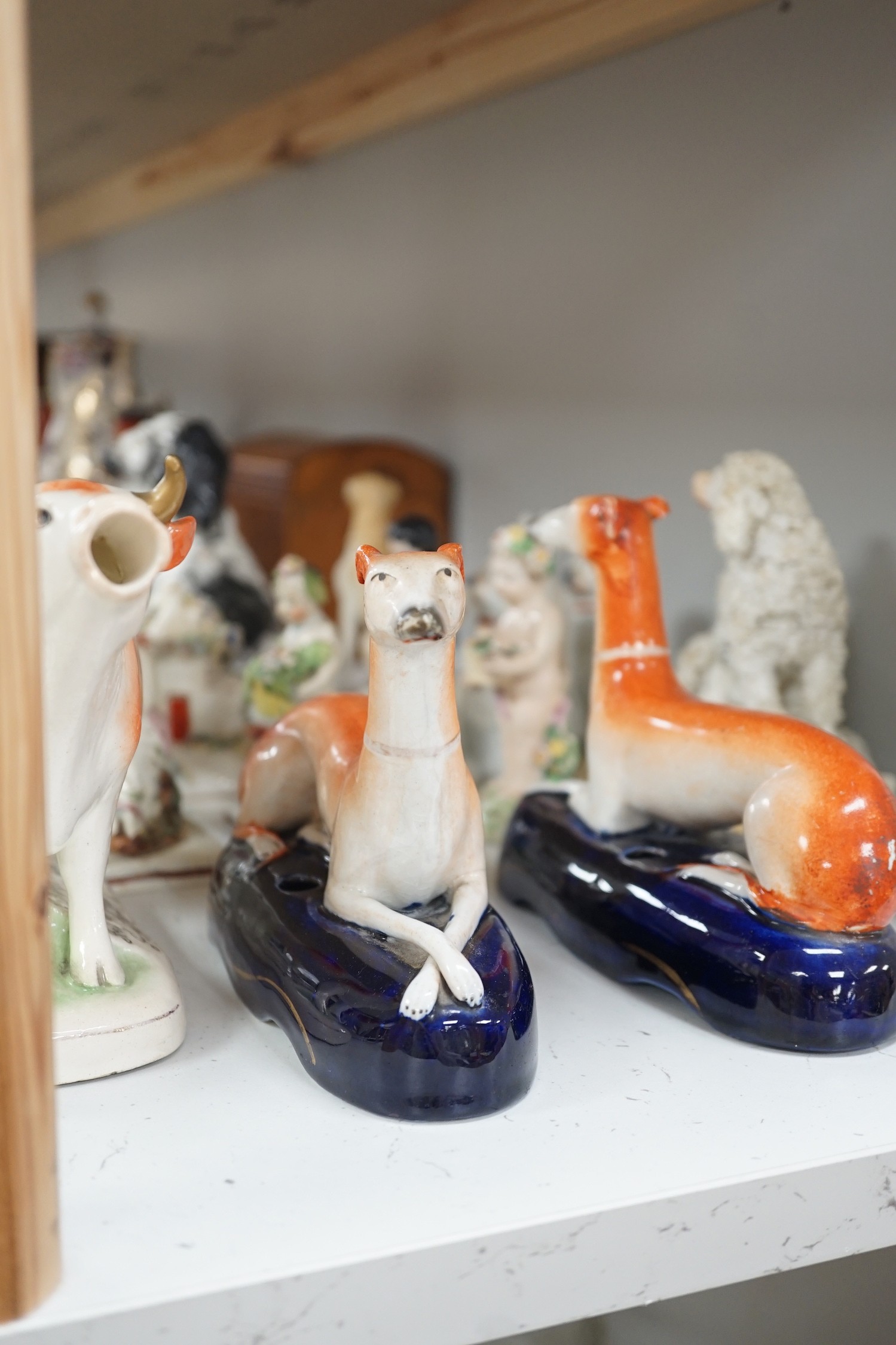 A quantity of Victorian Staffordshire animal figures, two pearlware putti and a Derby figure of a cherub, tallest 14.5 cm